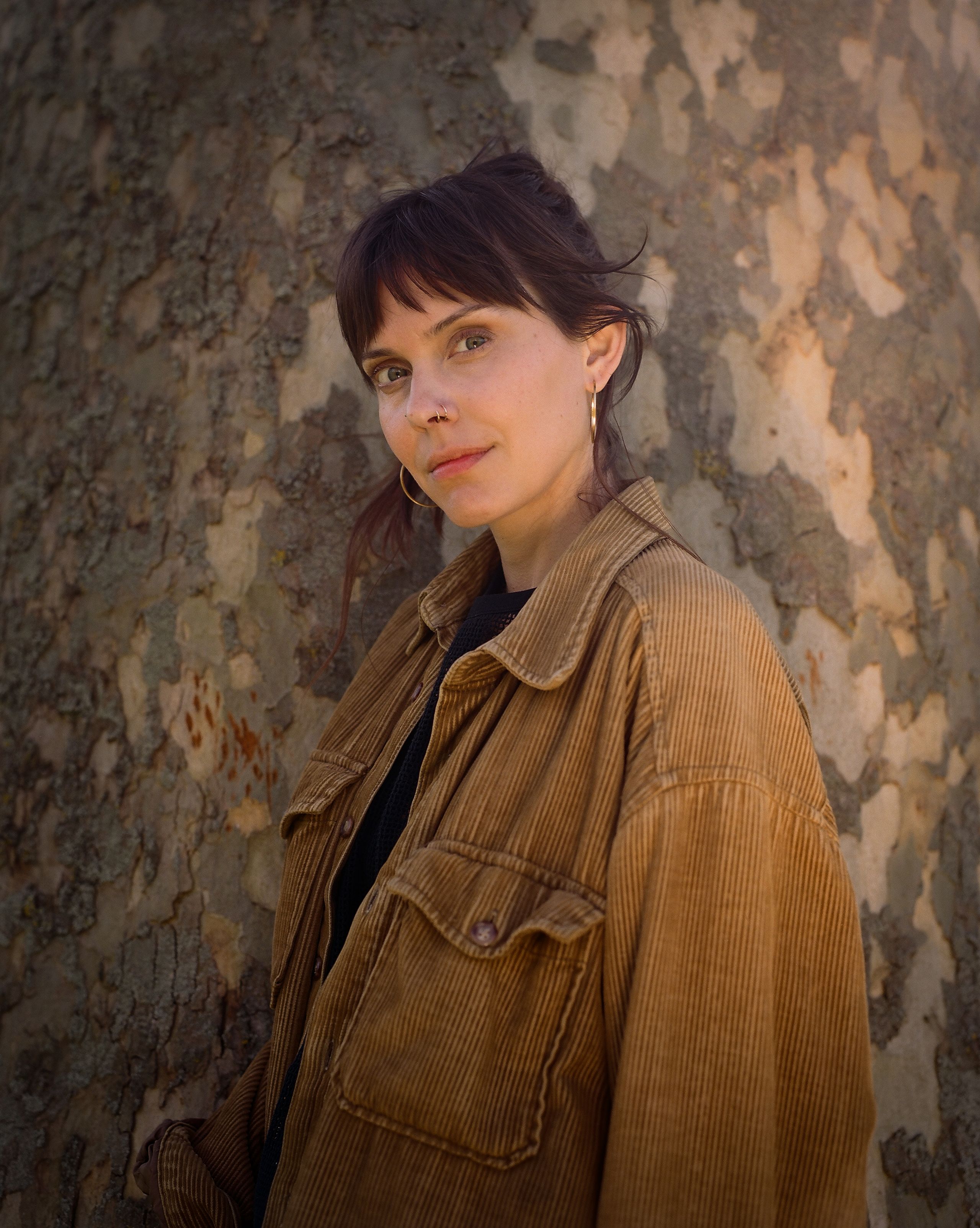 Image may contain Face Head Person Photography Portrait Black Hair Hair Happy Smile Clothing Coat and Jacket